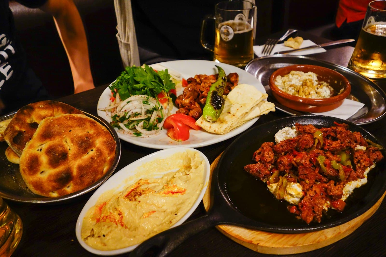 A table crowded with shared mezze plates and bread